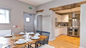 een keuken en eetkamer met een tafel en stoelen bij Manifold Farmhouse in Belper