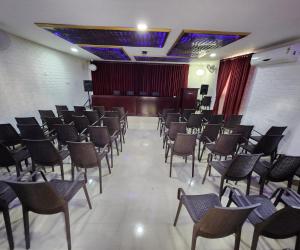 een kamer met stoelen en een podium in een kamer bij Bharatham Heritage Inn in Kannur