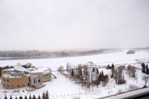um edifício na neve ao lado de um rio em гостиница Павлодар em Pavlodar