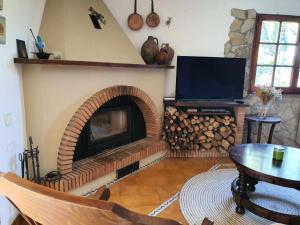 a living room with a fireplace with a tv at COSTA BRAVA SUITES Casa El Turó de Sagaró in S'Agaro