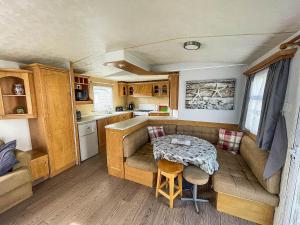 a kitchen with a couch and a table in a caravan at 8 Berth Caravan With Wifi At Dovercourt Holiday Park In Essex Ref 44009e in Great Oakley