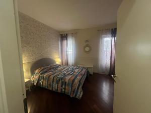 a bedroom with a bed and two windows at Scalette Pellicciai in Verona