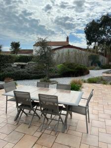 a white table and chairs on a patio at Les Chênes Verts in Le Grand Vieil