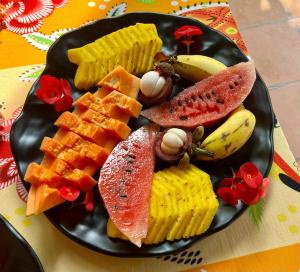 um prato preto de comida com frutas e waffles em MILLET'S FOOD COMPANY AND COOKING CENTER em Negombo