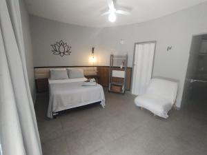 a bedroom with two beds and a chair at Villa São Lourenço in Bertioga