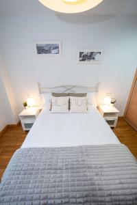 ein Schlafzimmer mit einem großen Bett mit zwei Nachttischen in der Unterkunft Dúplex Nalón in San Juan de la Arena