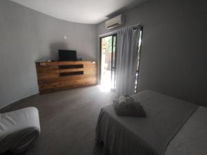 1 dormitorio con 1 cama, vestidor y ventana en Villa São Lourenço, en Bertioga