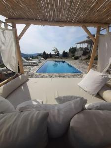 a view of a swimming pool with a couch in front at Müstakil havuzlu deniz manzaralı villa in Foca