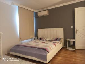 a bedroom with a large bed with a white headboard at Müstakil havuzlu deniz manzaralı villa in Foca