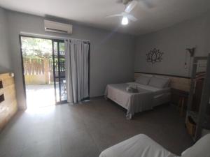 a bedroom with a bed and a sliding glass door at Villa São Lourenço in Bertioga