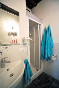 a bathroom with a sink and a shower with blue towels at Monolocale Gallo in Florence