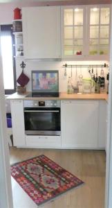 a kitchen with white cabinets and a stove at Ferienwohnung Kurparkblick in Bad Windsheim