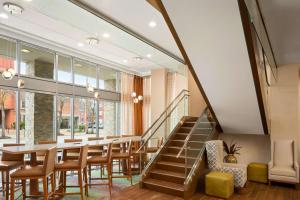 uma sala de jantar com uma mesa e cadeiras e uma escadaria em Hampton Inn and Suites Clayton/St. Louis-Galleria Area em Clayton