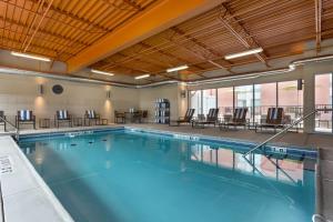 uma grande piscina com cadeiras e mesas em Hampton Inn and Suites Clayton/St. Louis-Galleria Area em Clayton