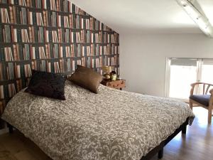 - une chambre avec un lit et un mur de livres dans l'établissement Le ventoux 1912, à Bédoin