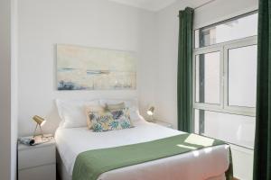 ein Schlafzimmer mit einem Bett und einem Fenster in der Unterkunft Apartamento do Carmo by An Island Apart in Funchal