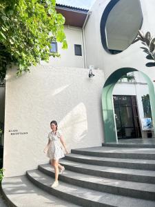 a woman in a dress walking down some stairs at 233Poshtel in Lampang