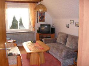 a living room with a couch and a table at Appartements im Moormerland in Warsingsfehn