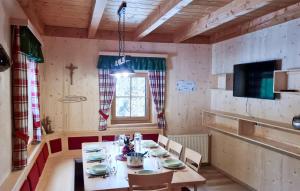 a dining room with a table and chairs and a television at 6 Bedroom Gorgeous Home In Lachtal - Schnberg in Hinteralm