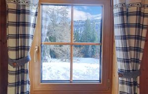 una finestra con vista su un cortile coperto da neve di Ferienhtte In Lachtal a Hinteralm