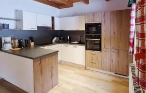 a kitchen with white cabinets and black appliances at Ferienhtte In Lachtal in Hinteralm