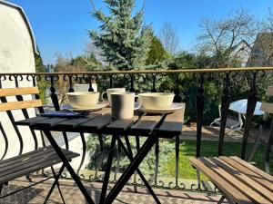 a table with cups and saucers on a balcony at Quiet Garden-View Studio Apartment in Düsseldorf