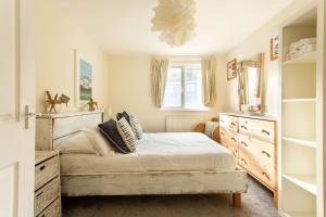 a bedroom with a bed and a window and shelves at Fabulous Beach Pad Just 20 Paces From The Sea in Mawgan Porth