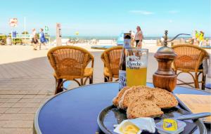 a table with a plate of bread and a bottle of beer at Beach Front Apartment In Oostende in Ostend