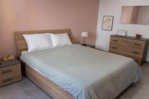 um quarto com uma grande cama branca e uma cómoda em Ta Xbiex Cityscape Apartment em Taʼ Xbiex