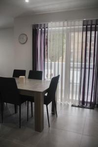uma sala de jantar com uma mesa de madeira e cadeiras em Ta Xbiex Cityscape Apartment em Taʼ Xbiex