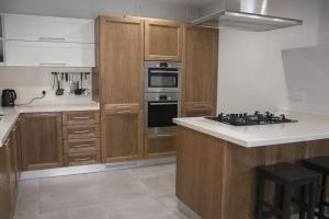 uma cozinha com armários de madeira e um forno com placa de fogão em Ta Xbiex Cityscape Apartment em Taʼ Xbiex