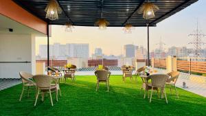a patio with tables and chairs on a roof at ZEN Medicity - Hotel & Serviced Apartments Gurgaon in Gurgaon