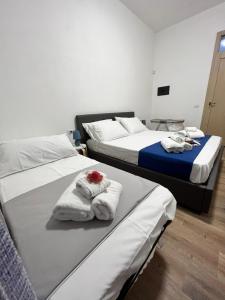 two beds in a room with towels on them at Baglio Eldama in Castelvetrano Selinunte