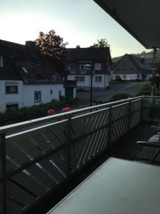 a balcony with a wooden fence and houses at Pension Sonnenheim in Winterberg