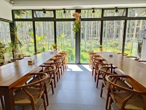 a row of tables and chairs in a room with windows at Roaming Cloud Sun Moon Lake B&B in Yuchi