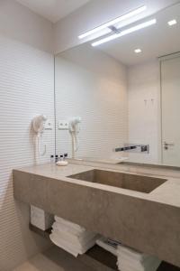 a bathroom with a large sink and a mirror at Porto Deluxe Palace in Porto