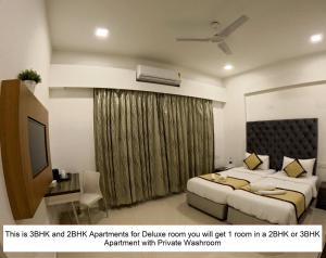 1 dormitorio con 1 cama grande y TV en Maxxvalue Apartment Chandivali, en Bombay