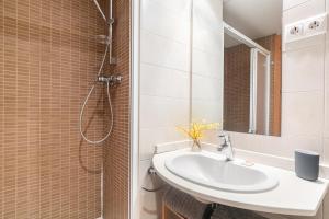 La salle de bains est pourvue d'un lavabo et d'une douche. dans l'établissement The Orbit Apartments, à Barcelone