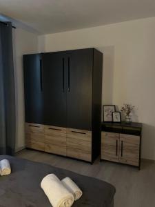 Un dormitorio con un gran armario negro y una cama en Cozy Apartment Sfanta Vineri Zalau en Zalău