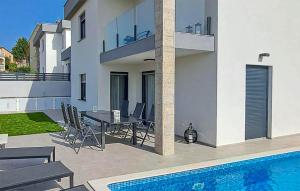 um pátio com uma mesa e cadeiras ao lado de uma piscina em Beautiful Home In Musales With Outdoor Swimming Pool em Mušalež