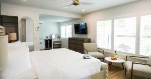 Ivory Sands Beach Suites في كليرووتر بيتش: غرفة نوم بسرير ابيض وغرفة معيشة