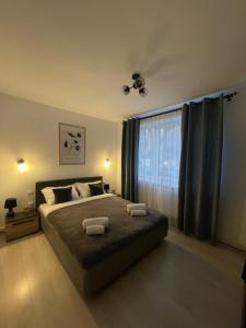 een slaapkamer met een groot bed en 2 handdoeken bij Cozy Apartment Sfanta Vineri Zalau in Zalău