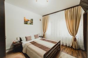 um quarto com uma cama e uma grande janela em Casa de Vinuri Vranceana 
