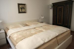 una camera da letto con un letto grande con lenzuola bianche di Ferienwohnungen am Holzmarkt a Bad Windsheim