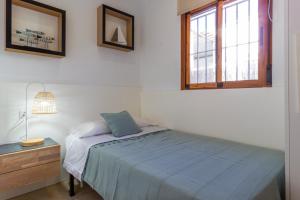 een slaapkamer met een bed en een raam bij Playa de Oliva, La Casita del mar in Oliva