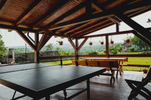 un patio con tavolo da ping pong e panche di Casa de Vinuri Vranceana 