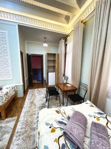 1 dormitorio con cama, escritorio y mesa en Rahmat guesthouse, en Bukhara