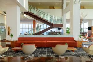 a lobby with a red couch and a staircase at Hotel Luzeiros São Luis in São Luís