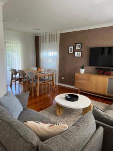 a living room with a couch and a table at Parkview Cottage in Henley Beach South