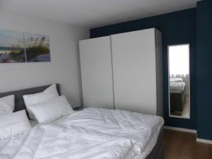 a bedroom with a white bed and a mirror at Ferienwohnungen Flora in Bad Windsheim